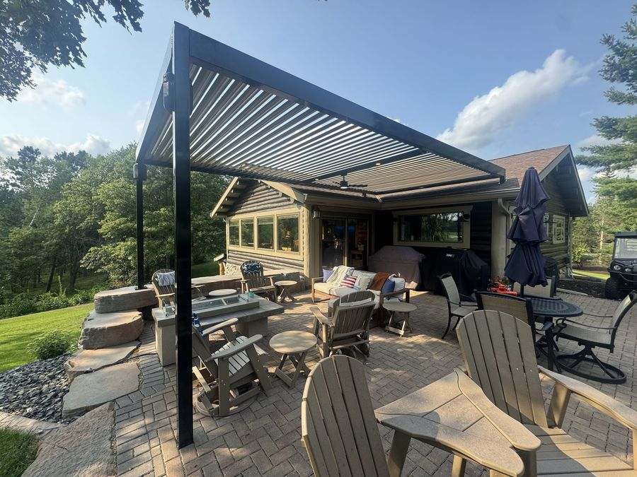 Bronze pergola over a paver patio at a lake cabin