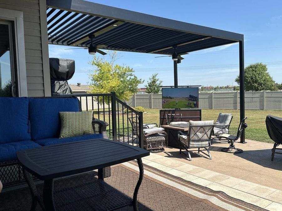 Pergola over a patio with fire table, television and seating